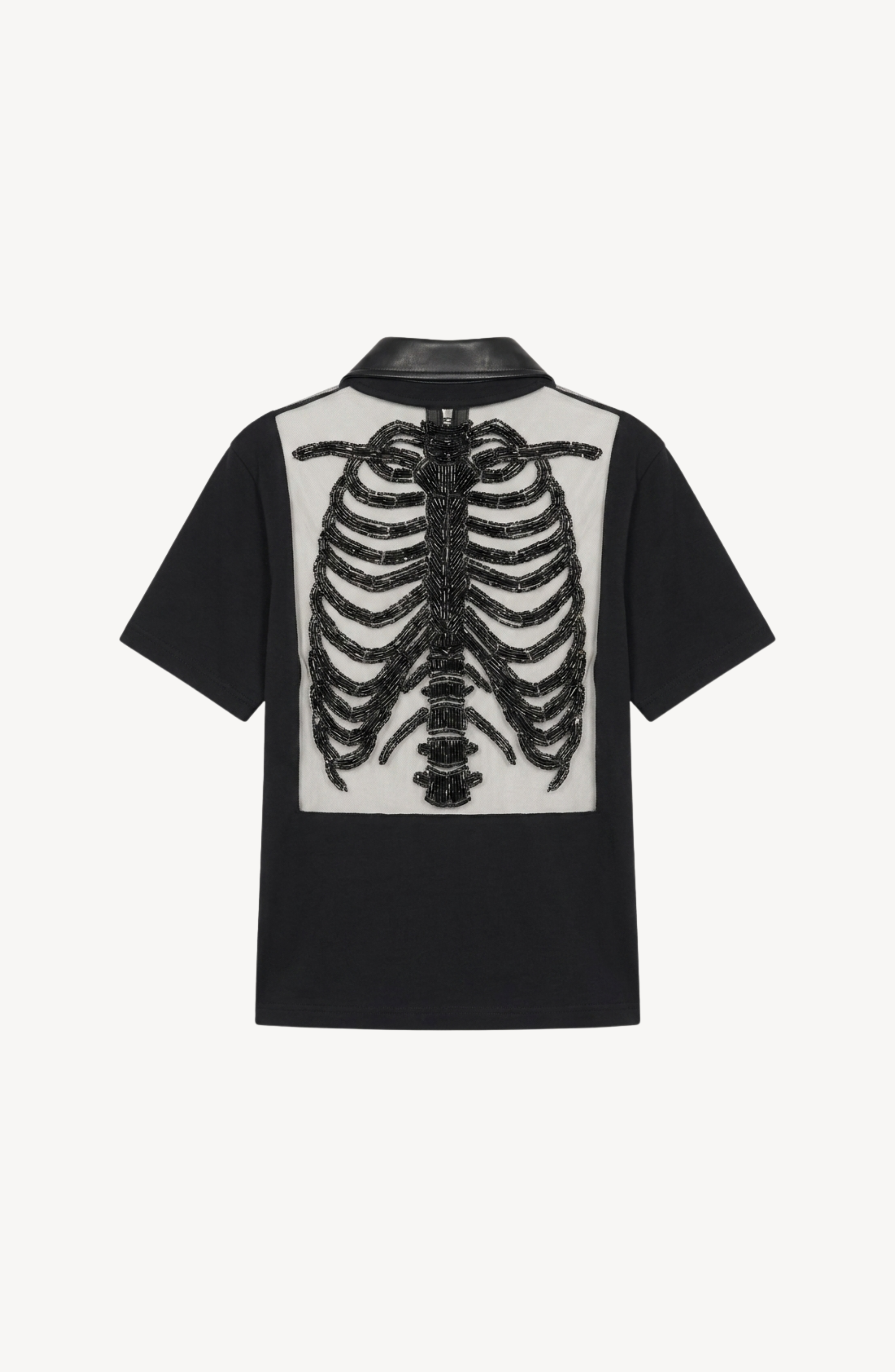 The LOULOU Beaded Skeleton Polo Top is a jet black, short-sleeve polo shirt showcasing an oversized embroidered black ribcage motif set on a white panel across the upper back.