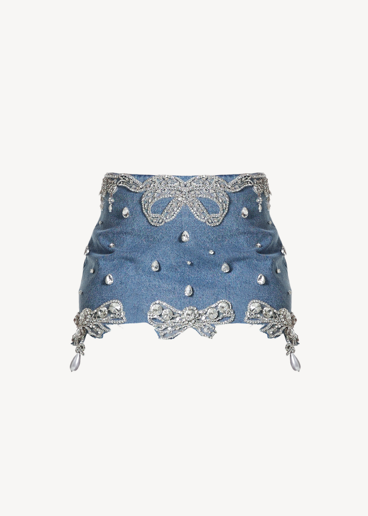 The LOULOU Belle Antoinette Skirt is a blue high-waisted denim mini skirt decorated with silver rhinestone bows, pearls, and sparkling studs, displayed on a plain white background.