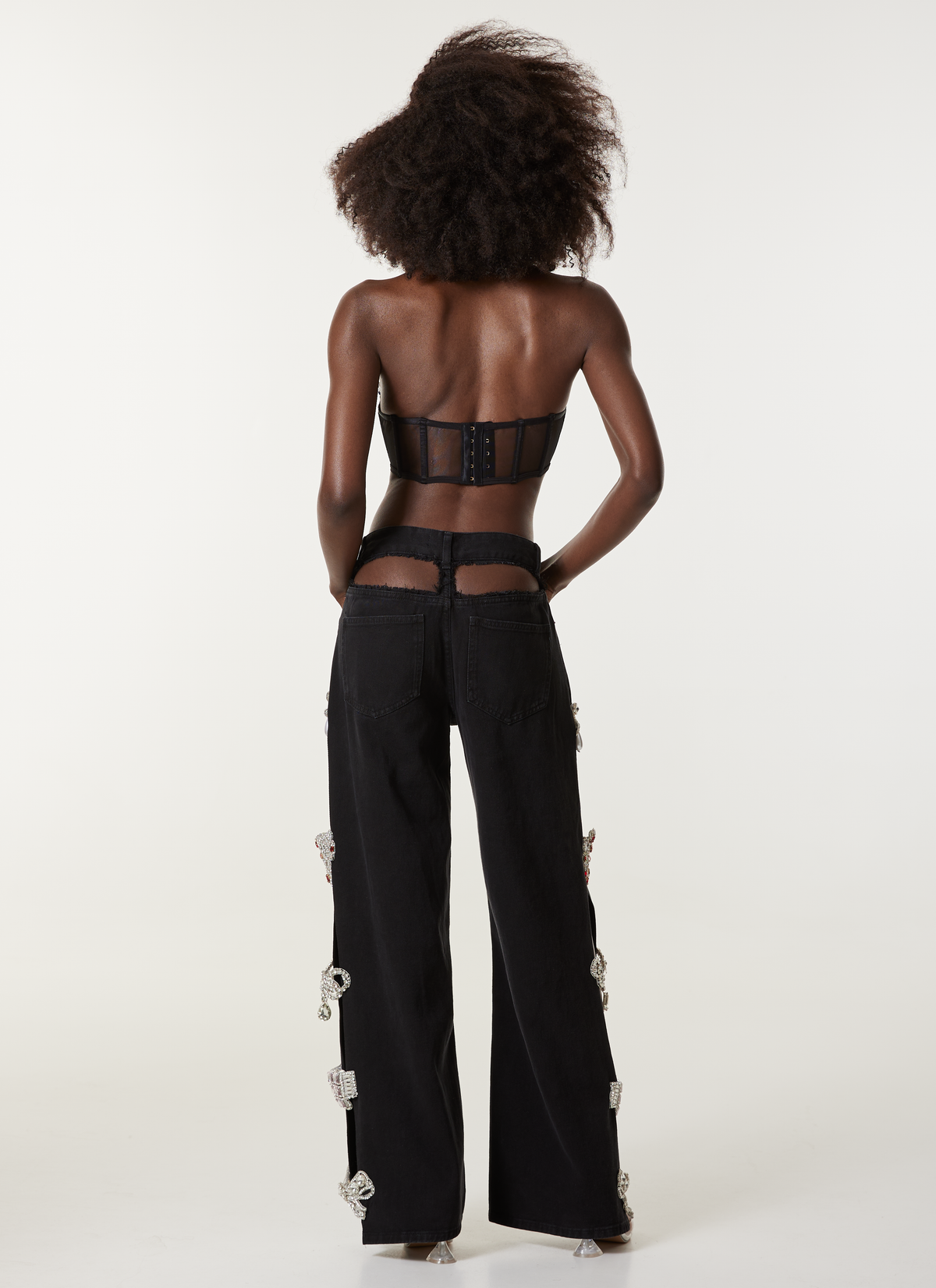 LOULOU Black Cut-Out Crystal Denim Jeans back view with black denim construction and visible crystal side detailing.
