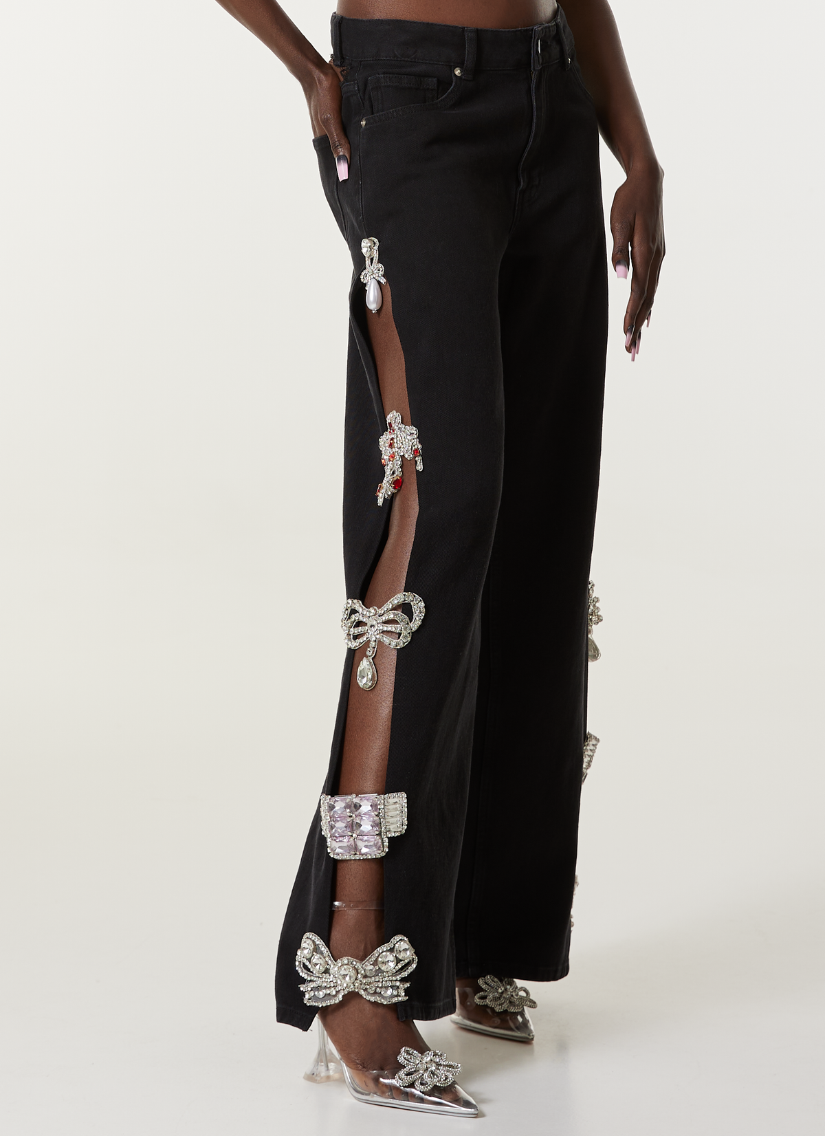LOULOU Black Cut-Out Crystal Denim Jeans detail view with side cut-out panels and crystal embellishment, styled with pointed heels.