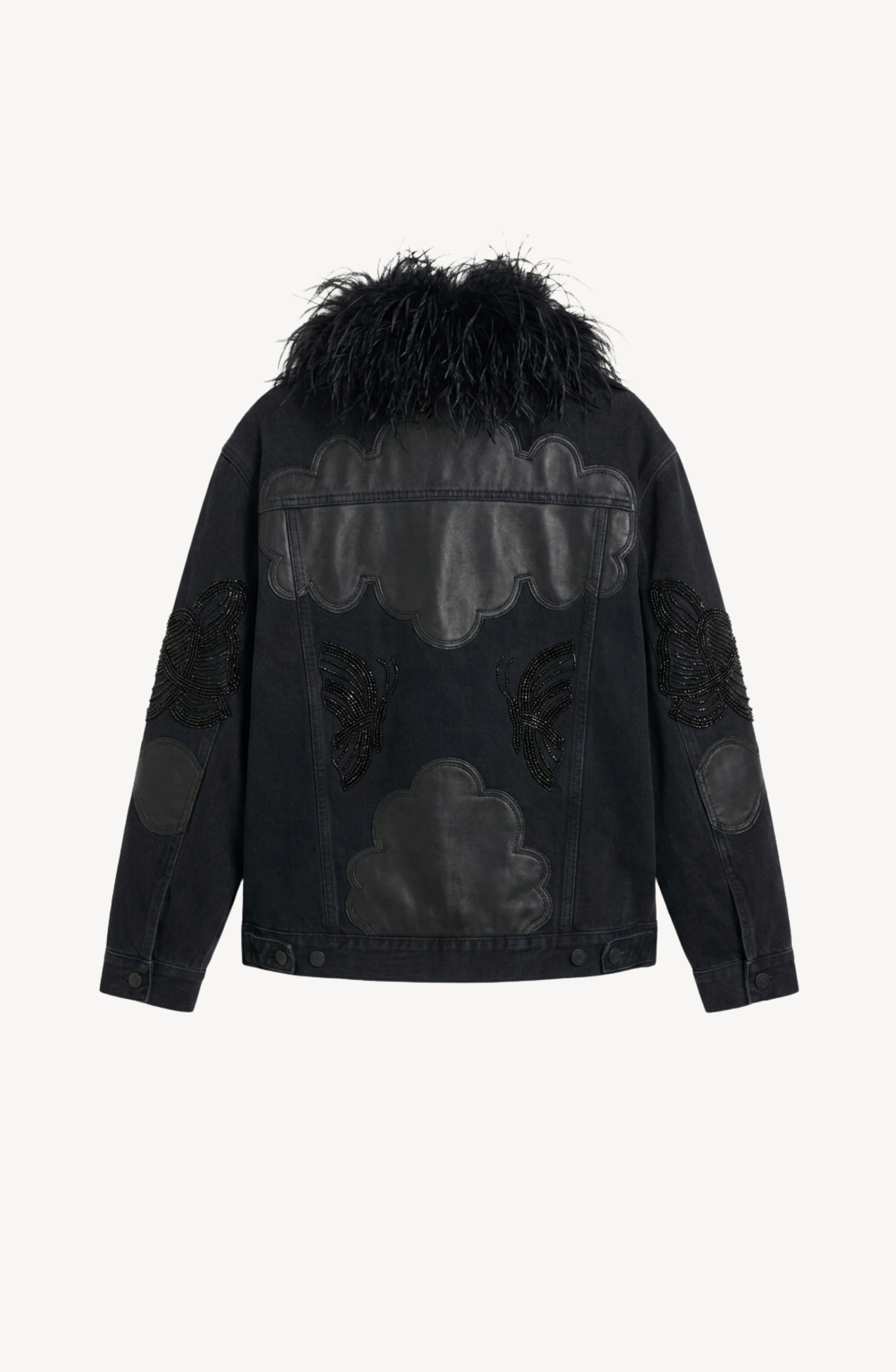 The Feather-Trimmed Appliqué Denim Jacket by LOULOU features an oversized black denim silhouette adorned with eye-catching leather cloud and butterfly appliqué patches on the back and sleeves. The collar is detailed with plush black faux fur, and the jacket is shown against a plain white background.