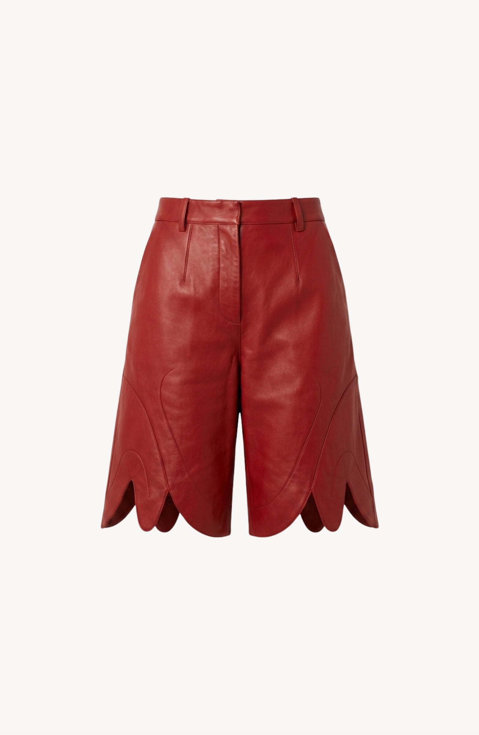 The LOULOU Red Leather Bermuda Shorts are high-waisted and crafted from lamb leather in a vibrant red hue. They feature scalloped hems, front pleats, belt loops, and side pockets, and are shown against a plain white background.