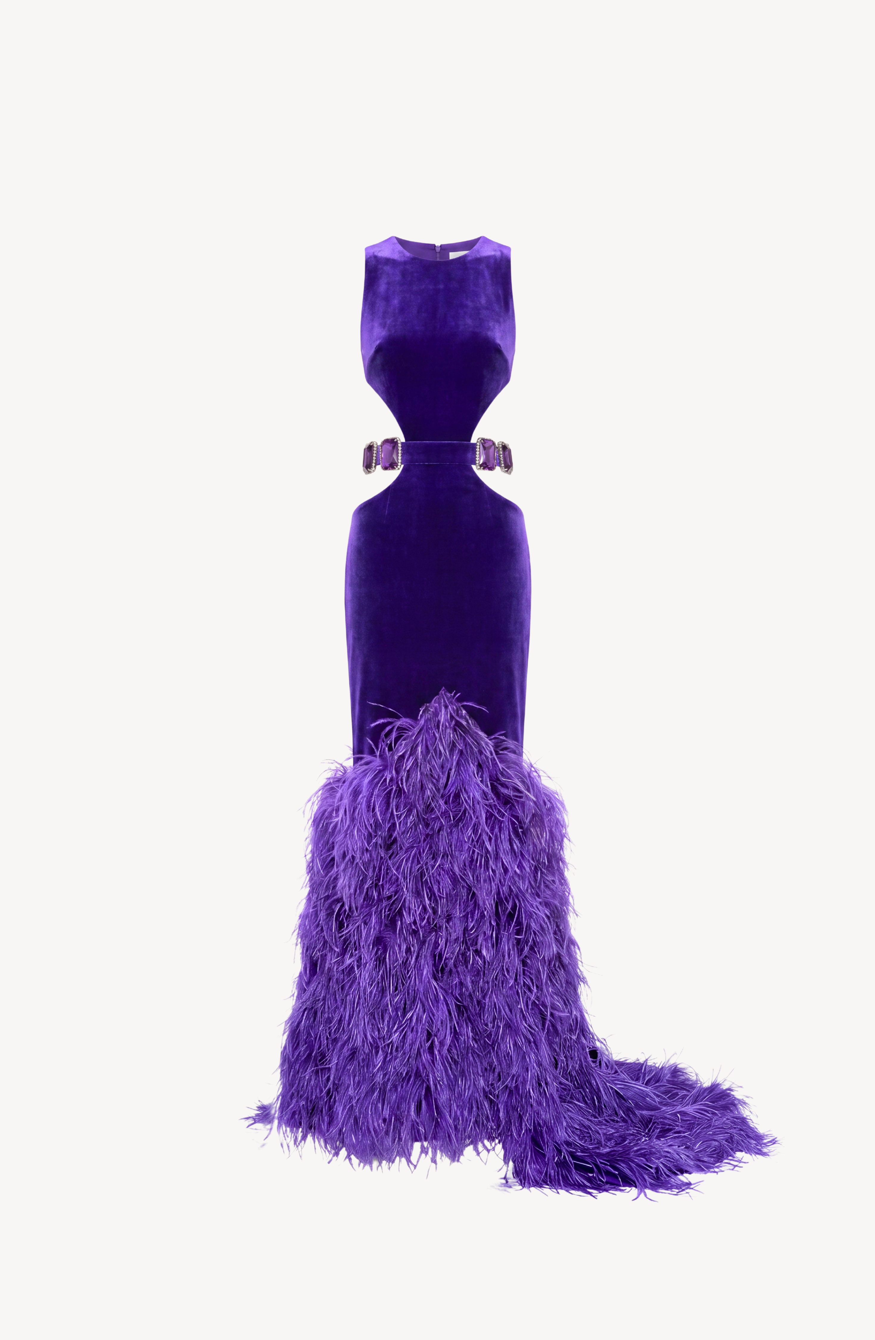The LOULOU Velvet Cutout Feather Gown is a sleeveless, floor-length purple velvet evening dress featuring cutout sides, a belted waist adorned with sparkling crystal buckles, and a dramatic feather-trimmed skirt and train, displayed on a white background.