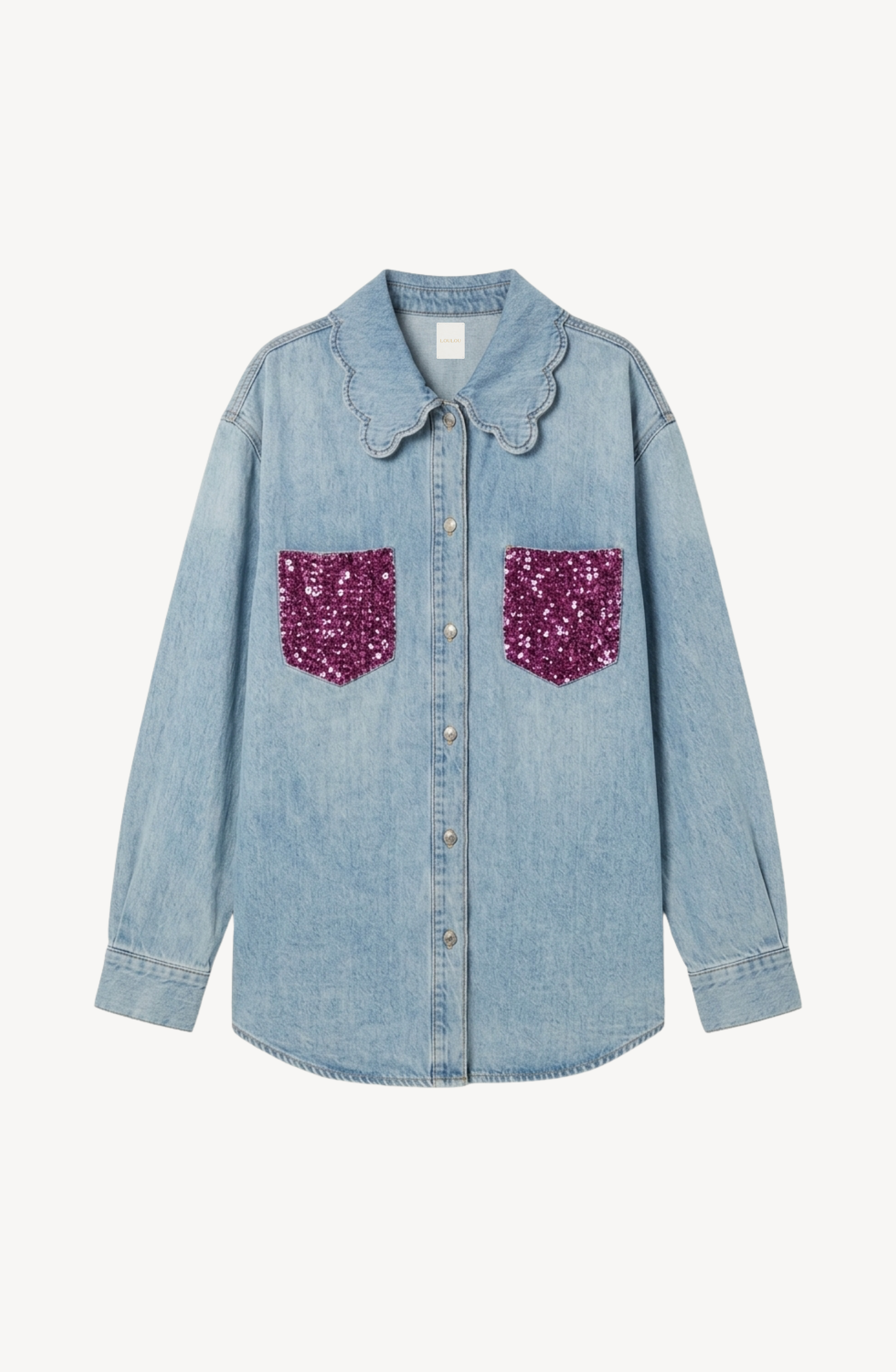 The LOULOU Sequin Pocket Denim Shirt showcases a light wash design, accented with a charming scalloped collar and vibrant purple sequin chest pockets, all presented against a clean white background.